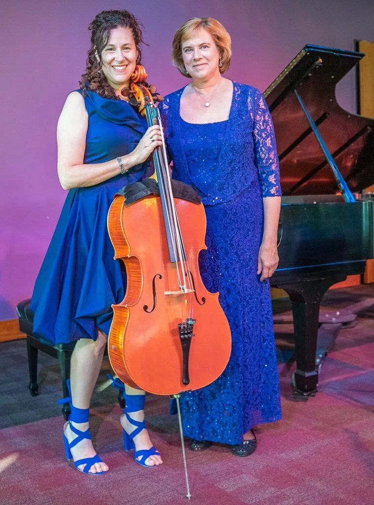 Amy Sue Barston with her cello and Audrey Andrist beside a grand piano