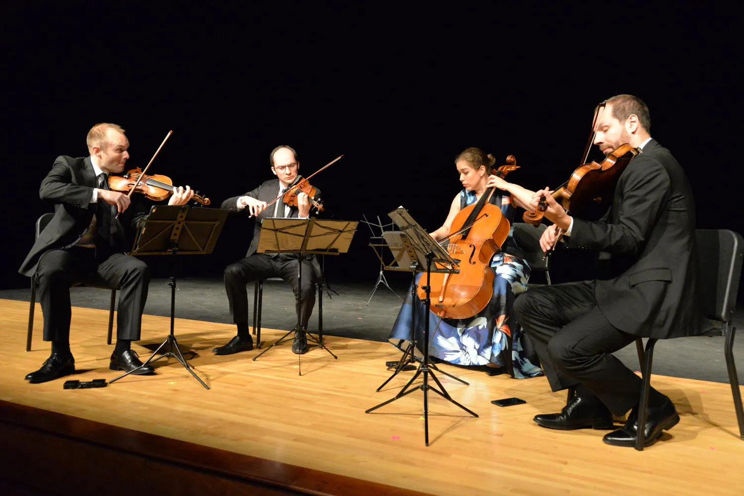 A string quartet playing on a wooden stage