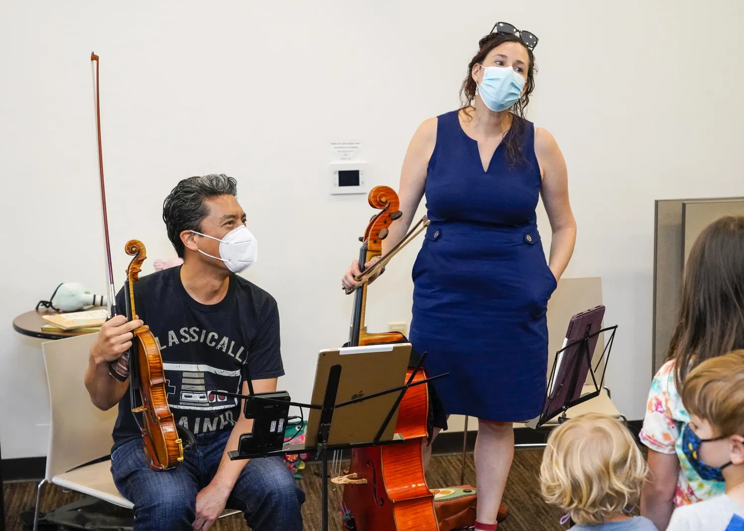 A cellist greeting children