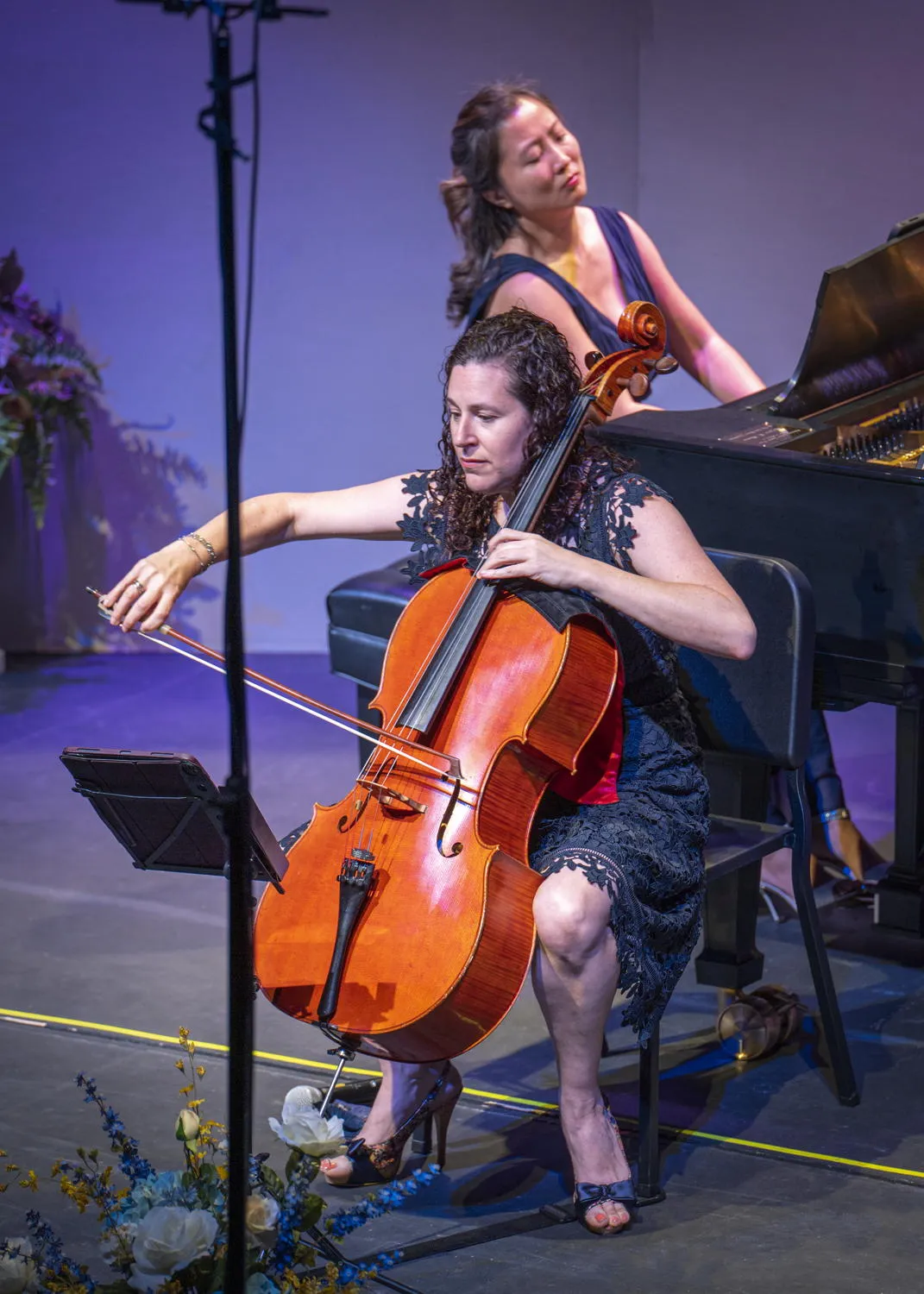 A cellist playing in front of a pianist at a grand piano