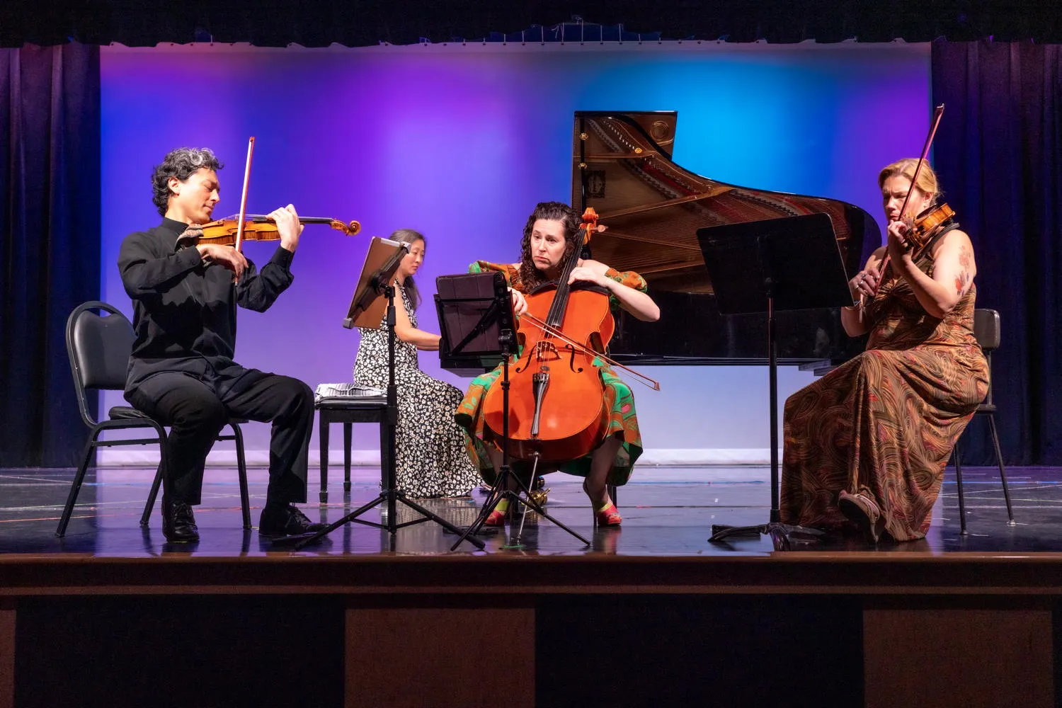 A pianist and three string players on a purple-lit stage at Formal Concert #2