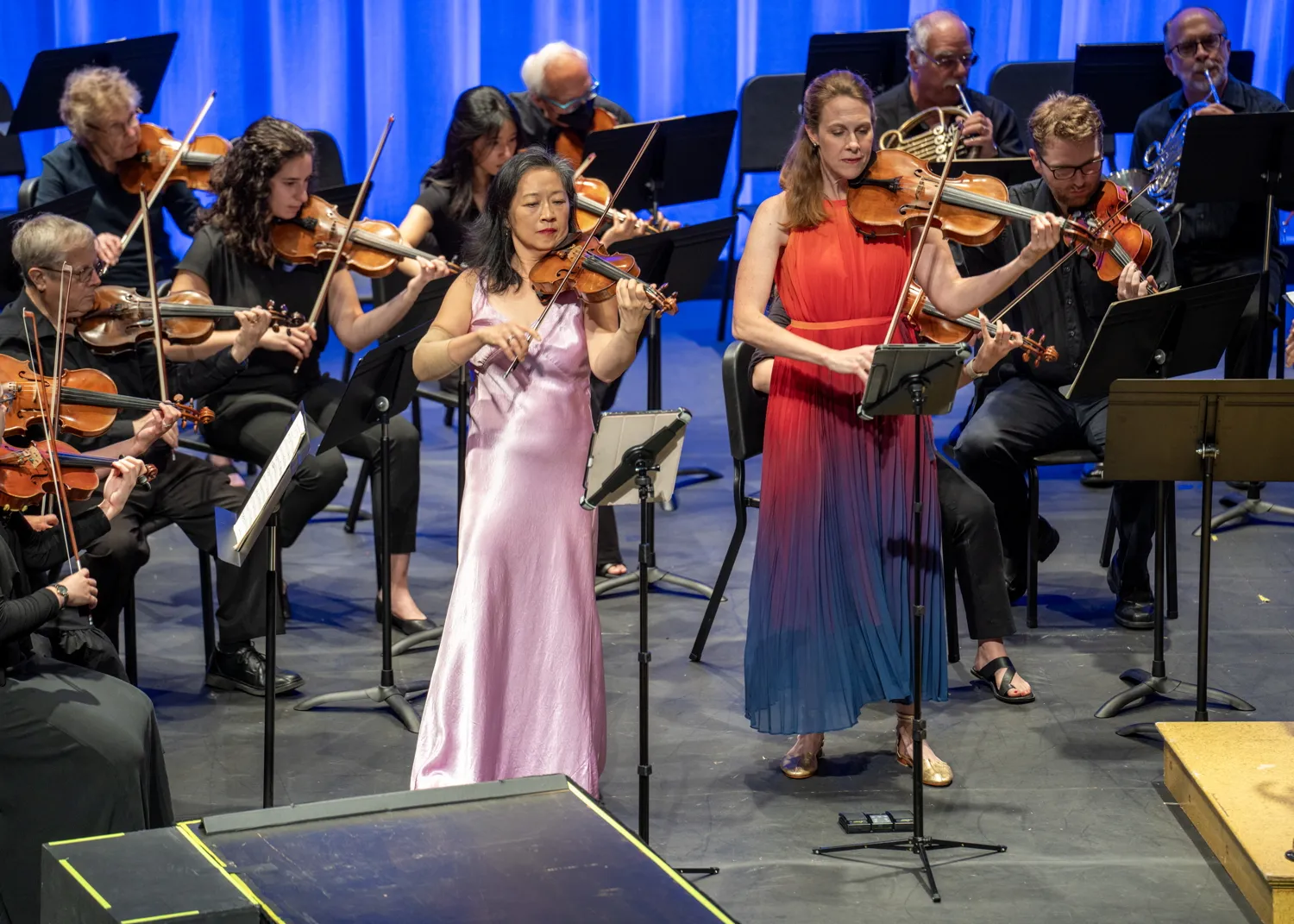 Violin and viola soloists playing in front of the orchestra