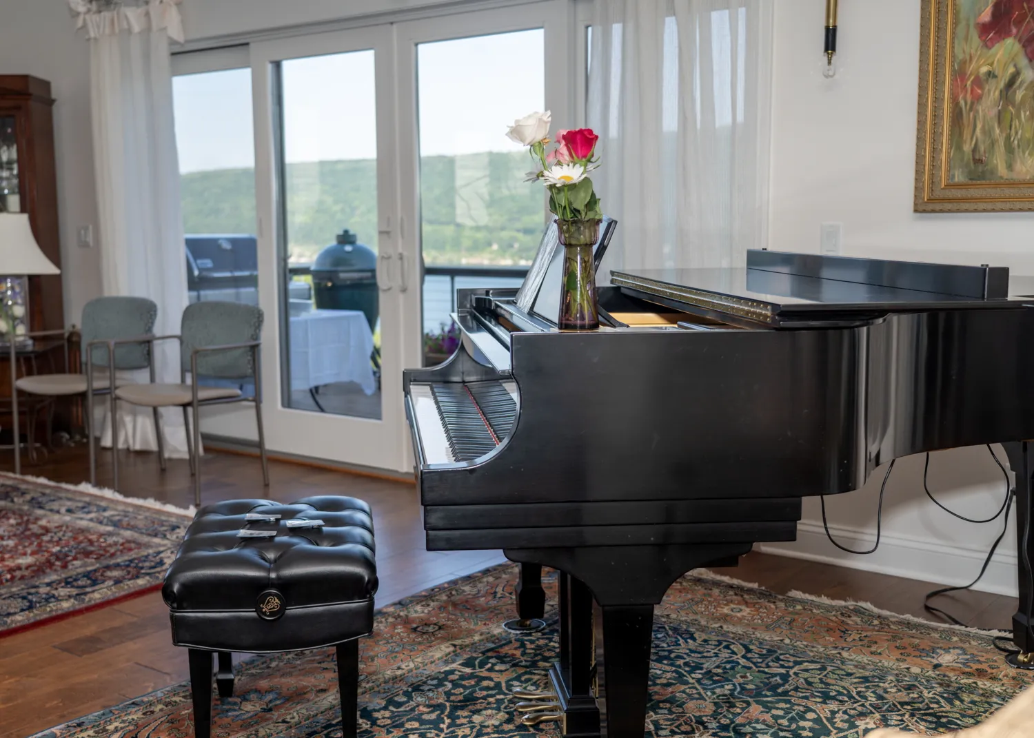 A grand piano by the windows, with roses on the lid