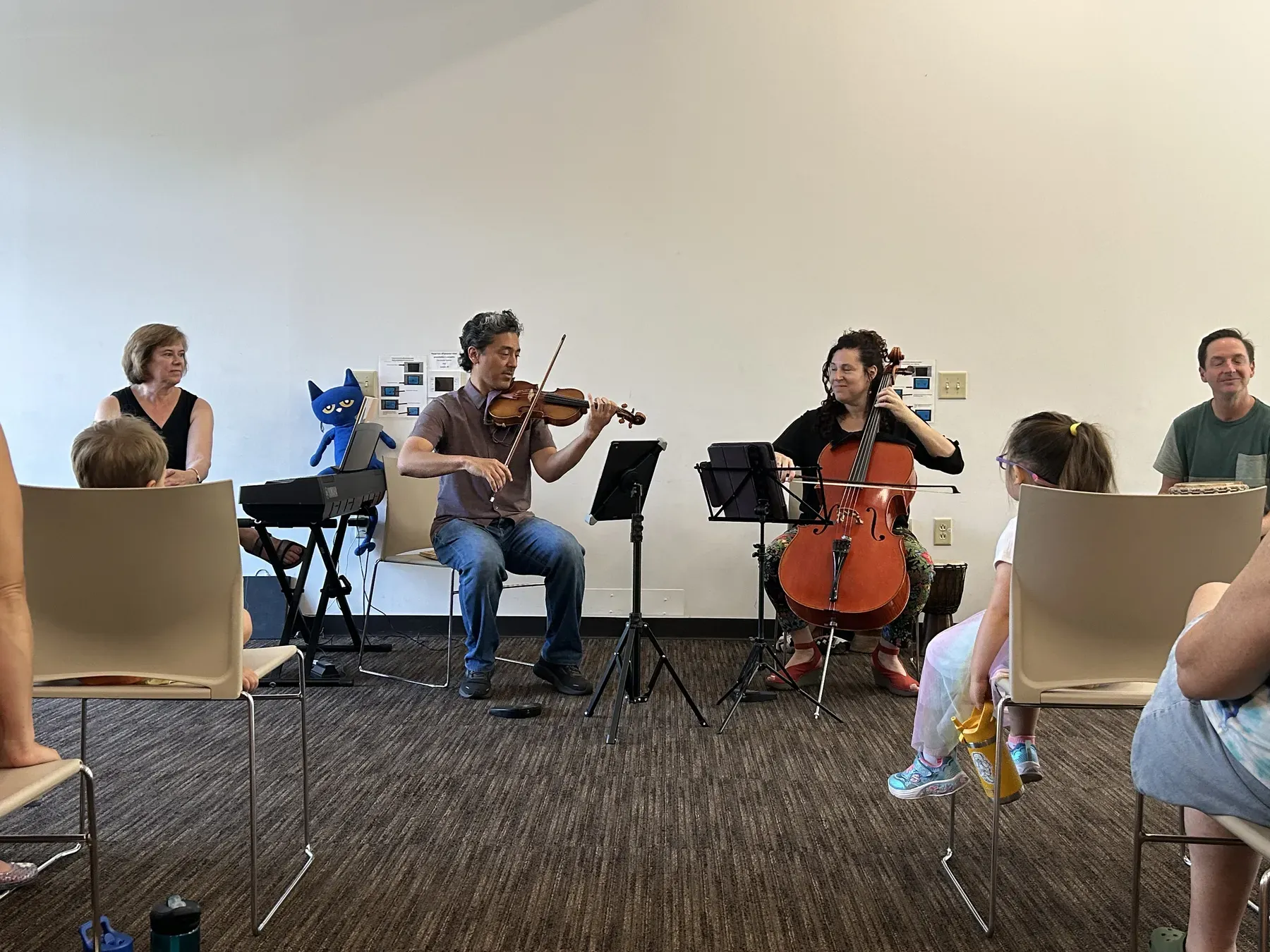 A violinist and a cellist playing for children at Wood Library