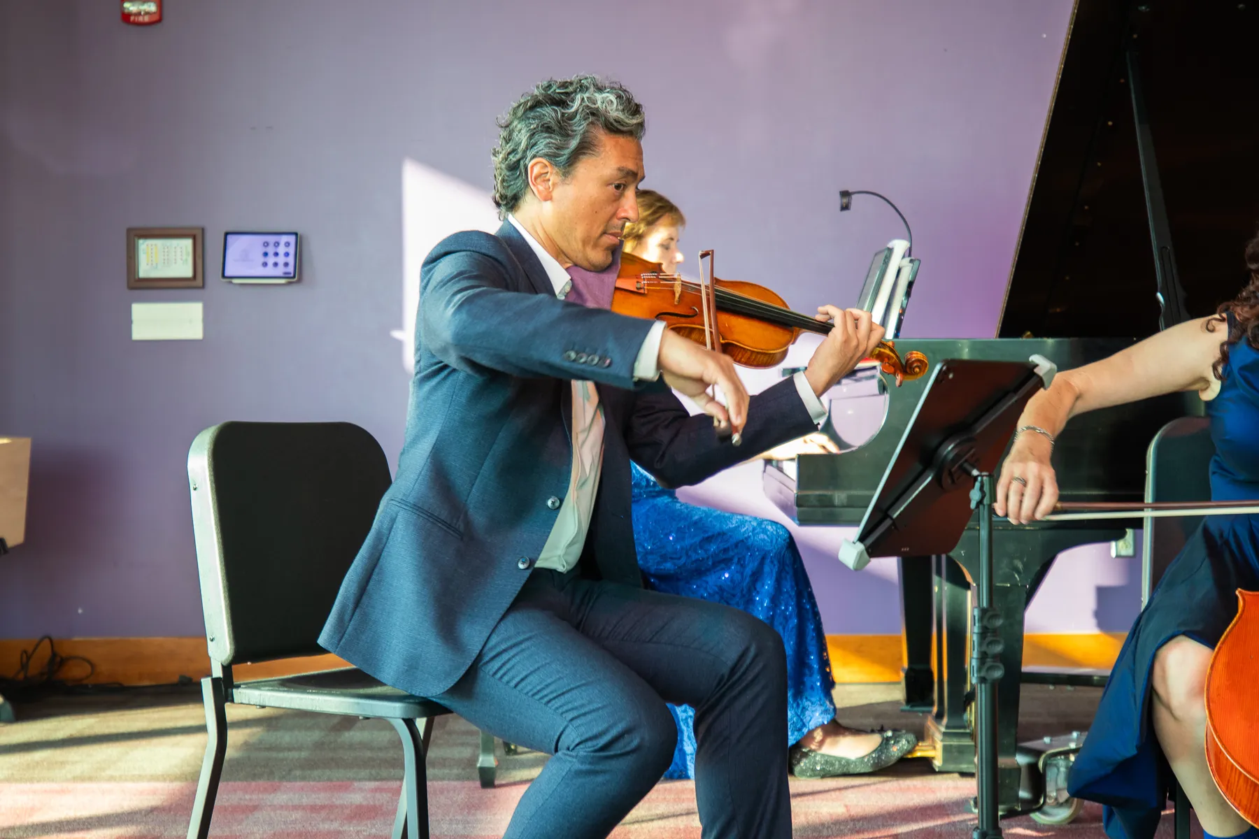 Kevin Kumar playing violin beside the piano