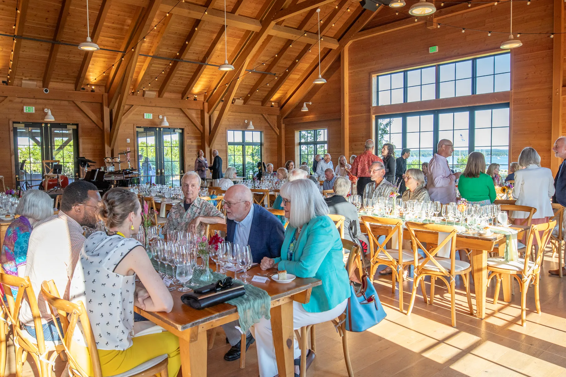 Guests talking at long tables in The Lake House hall