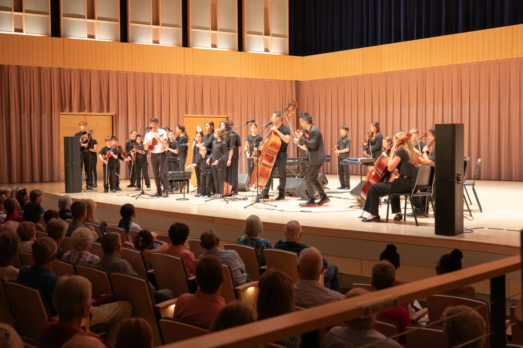 Time for Three joined on stage by a large group of young string players
